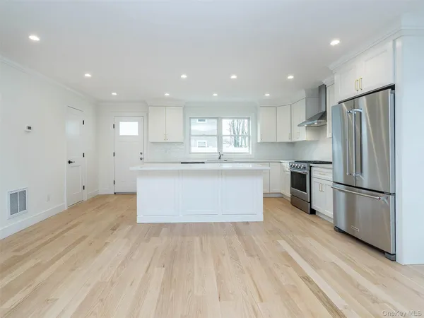 a kitchen with stainless steel appliances a stove a refrigerator and cabinets