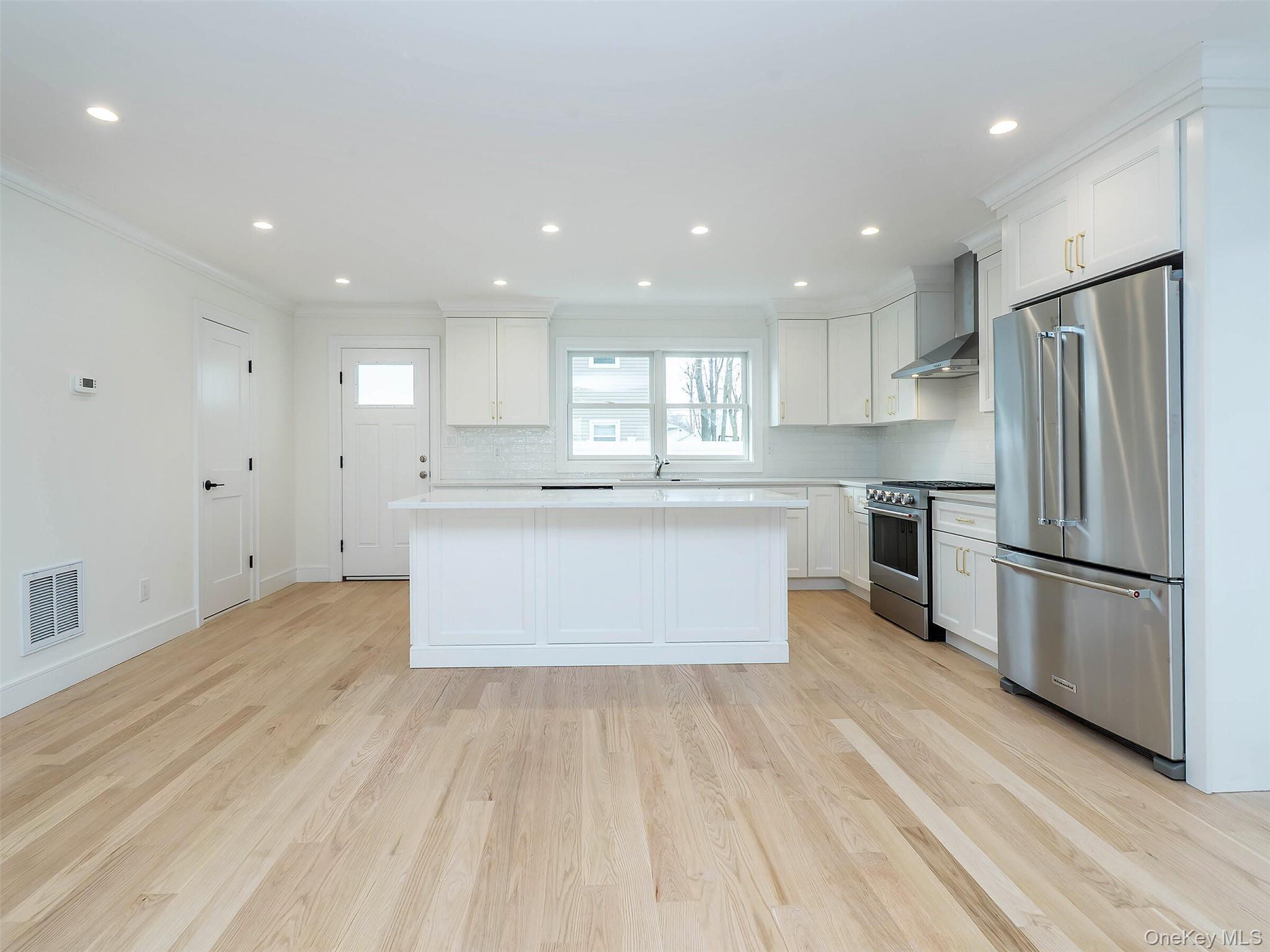 35 B Dunwood Road Port Washington, NY 11050 - Photo 8 of 35 a large kitchen with stainless steel appliances refrigerator a center island and a stove