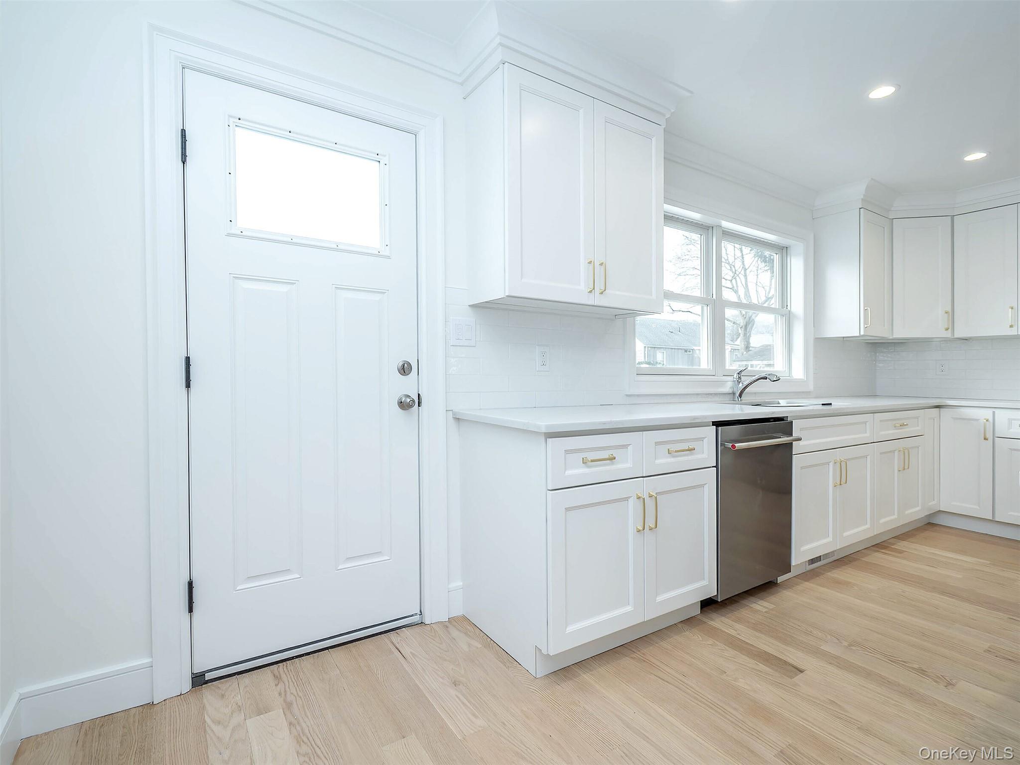35 B Dunwood Road Port Washington, NY 11050 - Photo 10 of 35 a kitchen with white cabinets and white appliances