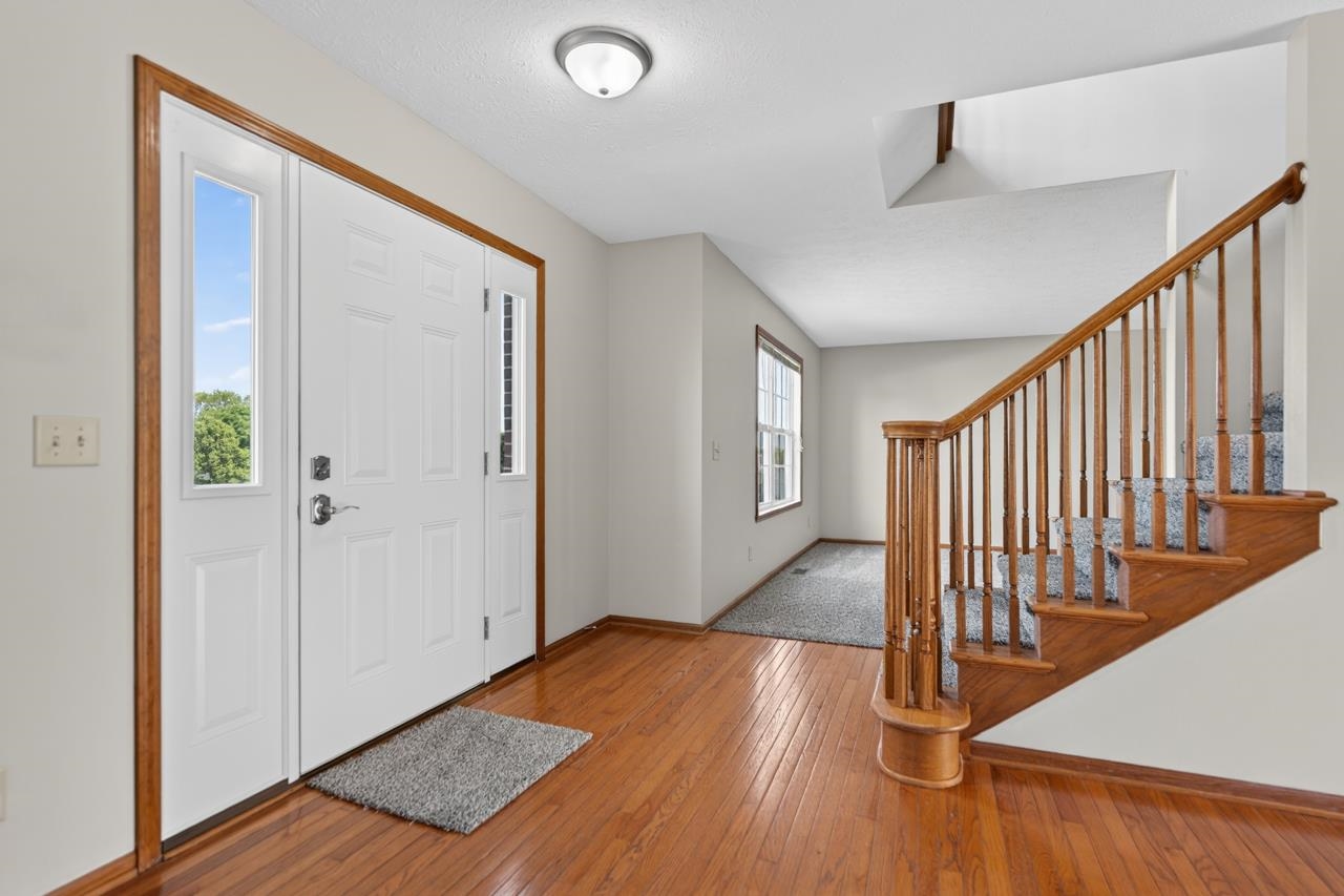 676 Elberon Way Roscoe, IL 61073 - Photo 3 of 30 a view of a hallway with wooden floor and staircase