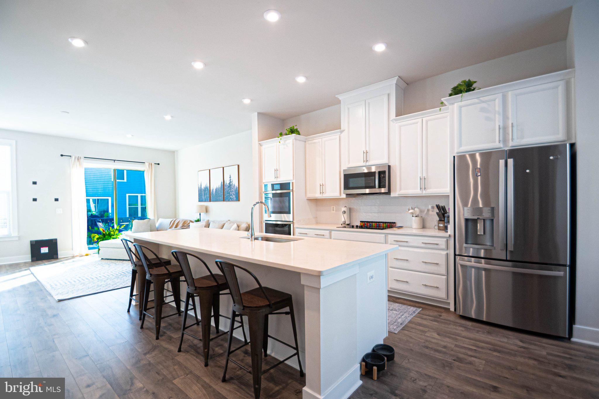 2453 Liberty Loop Herndon, VA 20171 - Photo 16 of 52 a kitchen with stainless steel appliances a refrigerator a stove a sink a dining table and chairs