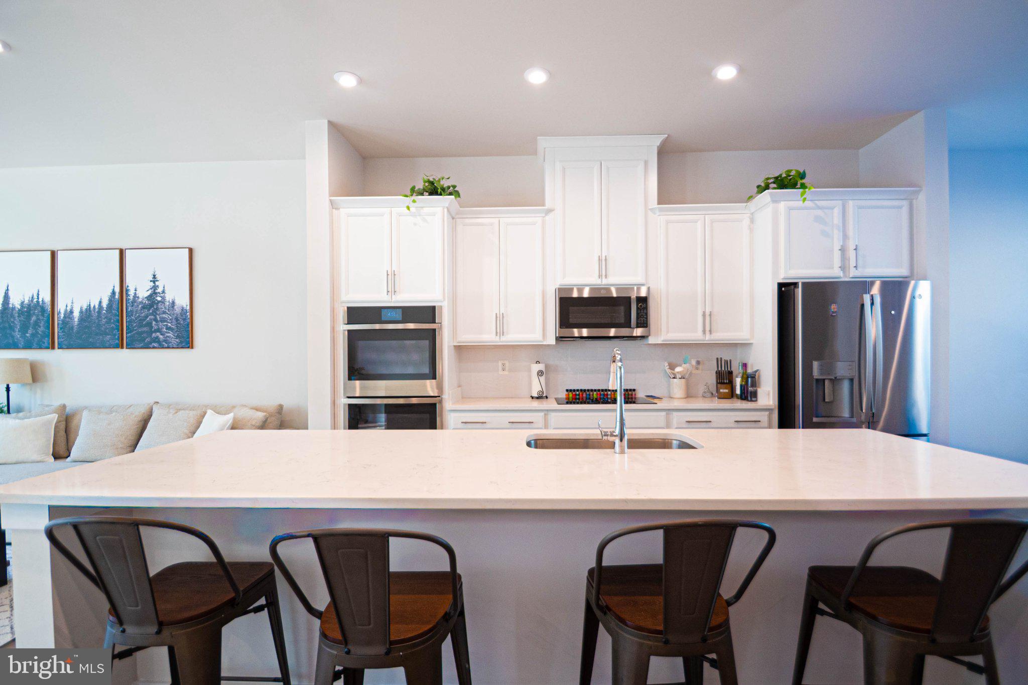 2453 Liberty Loop Herndon, VA 20171 - Photo 20 of 52 a kitchen with stainless steel appliances a white table chairs refrigerator and microwave
