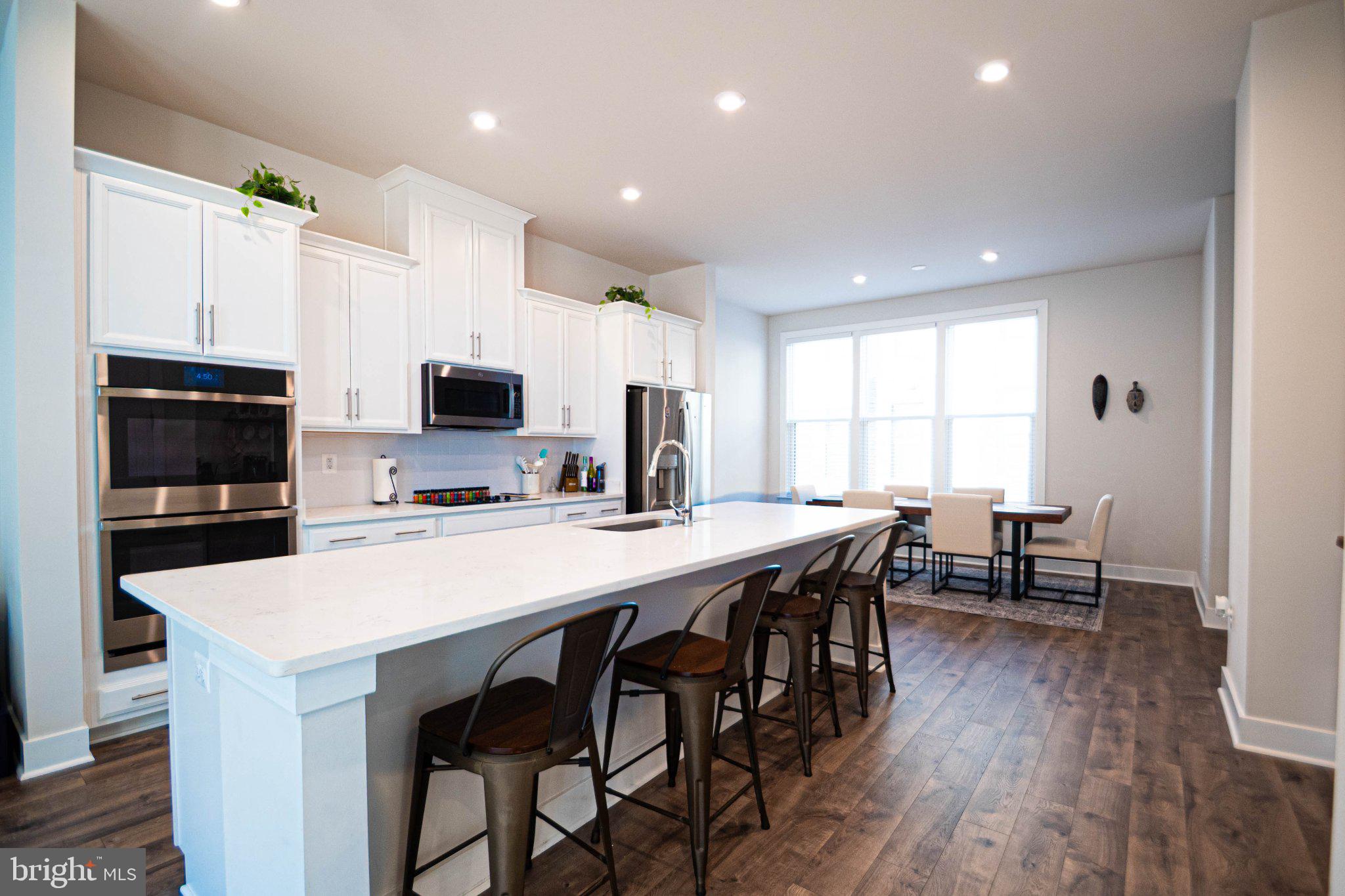 2453 Liberty Loop Herndon, VA 20171 - Photo 23 of 52 a kitchen with stainless steel appliances a table chairs refrigerator and microwave