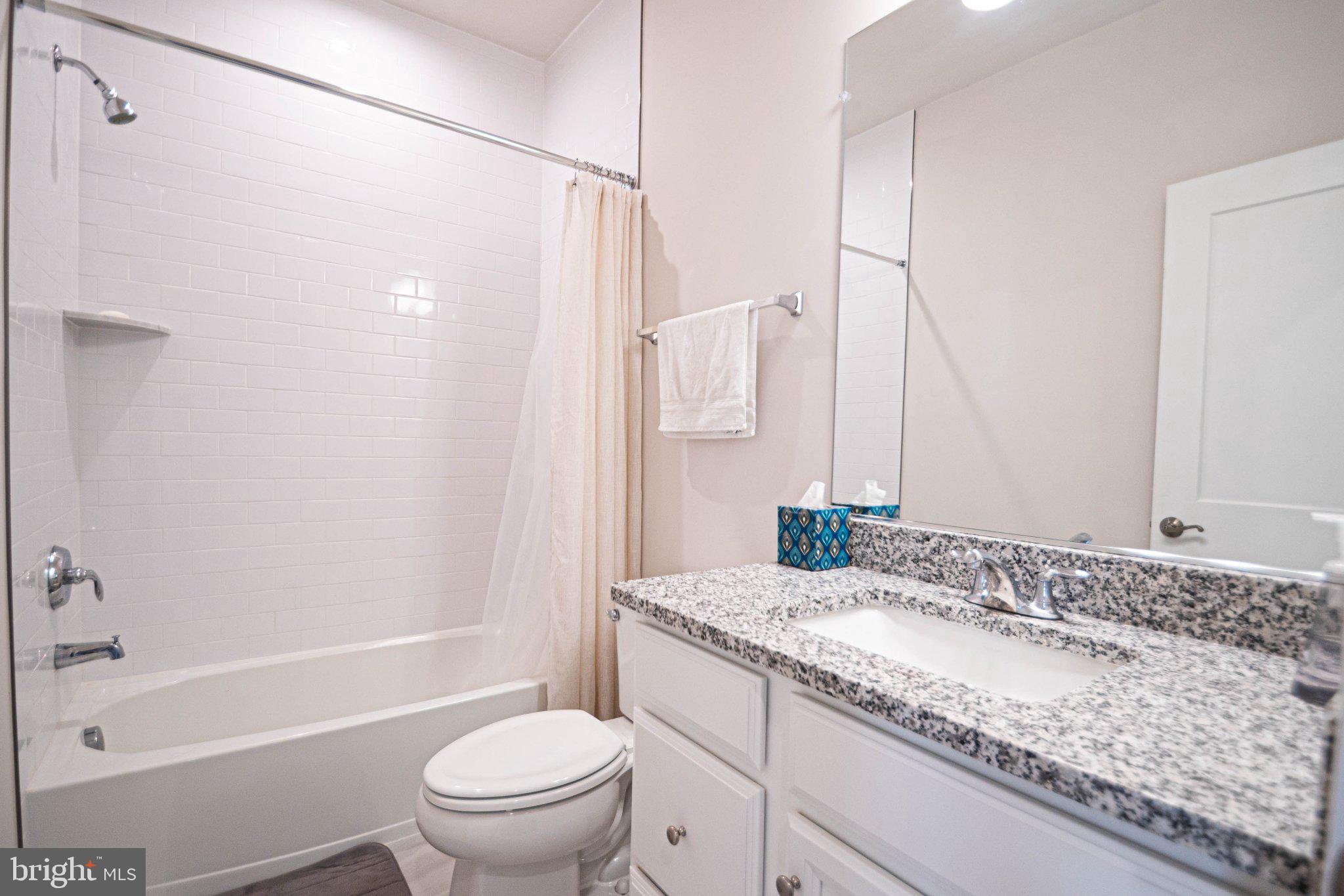 2453 Liberty Loop Herndon, VA 20171 - Photo 33 of 52 a bathroom with a granite countertop sink a toilet and shower