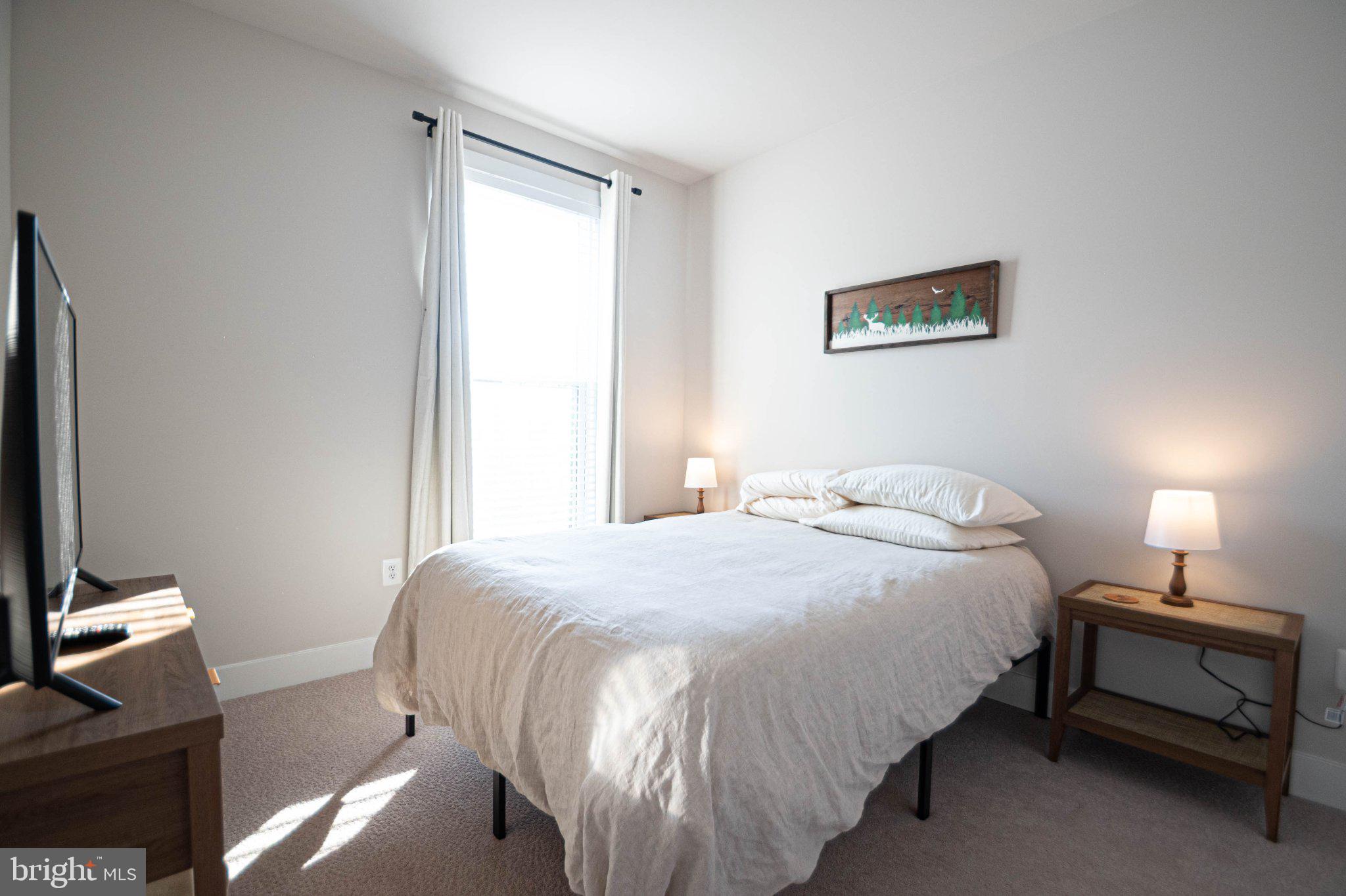 2453 Liberty Loop Herndon, VA 20171 - Photo 36 of 52 a bedroom with a bed and a lamp