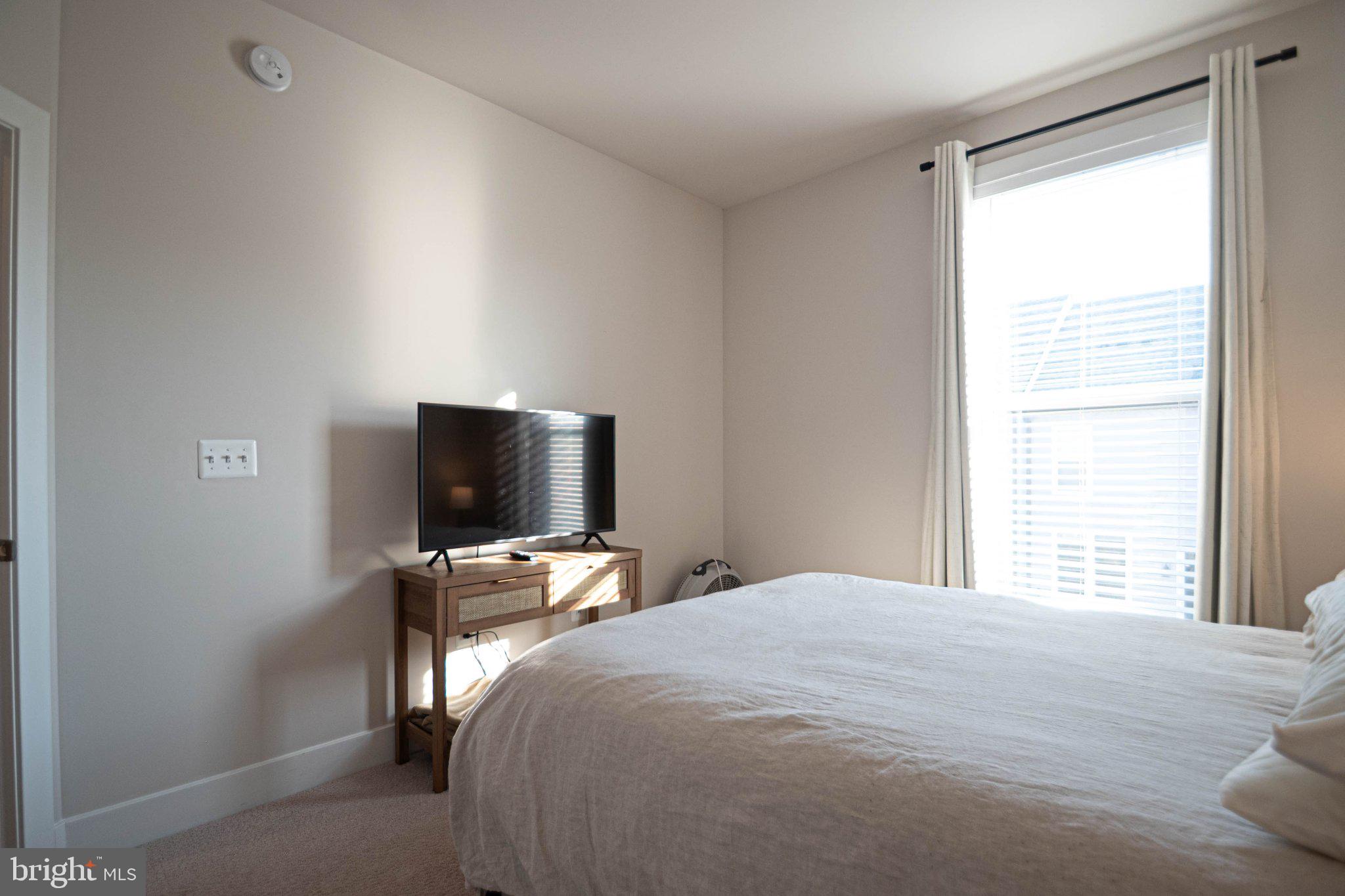 2453 Liberty Loop Herndon, VA 20171 - Photo 37 of 52 a bedroom with a bed and a flat tv screen on the dresser