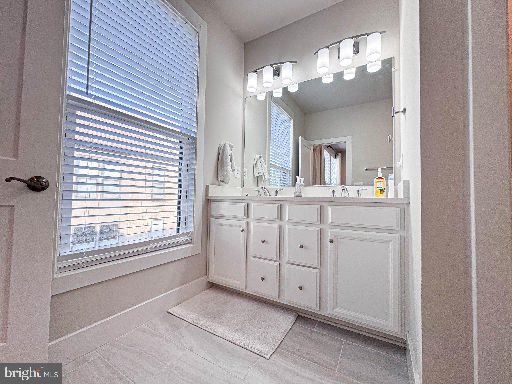 2453 Liberty Loop Herndon, VA 20171 - Photo 6 of 52 a spacious bathroom with a double vanity sink a mirror a lamp and window