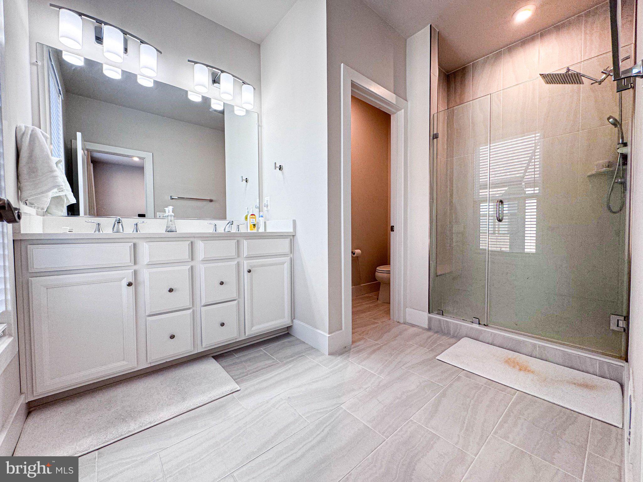 2453 Liberty Loop Herndon, VA 20171 - Photo 7 of 52 a spacious bathroom with a double vanity sink a large mirror and shower
