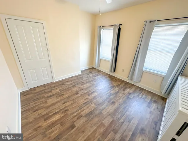 an empty room with wooden floor and entrance