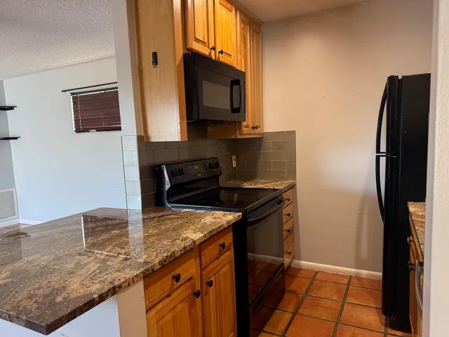 a kitchen with granite countertop a sink stove and refrigerator