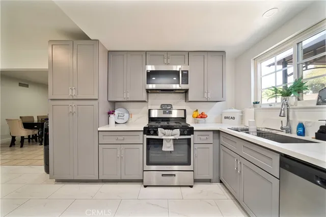 a kitchen with stainless steel appliances granite countertop a sink and a stove