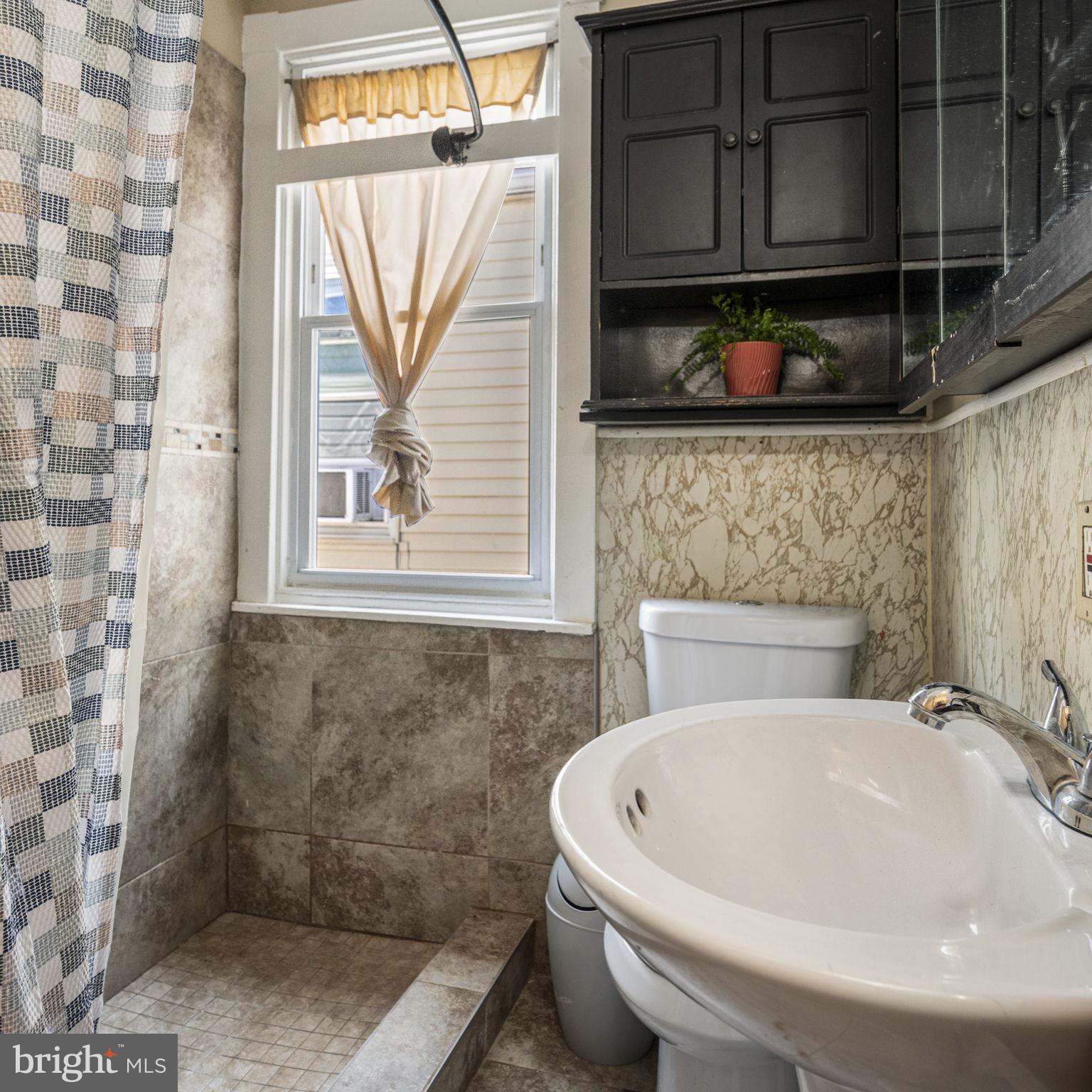 115 Park Avenue Reading, PA 19605 - Photo 14 of 28 a bathroom with a sink a mirror and a shower
