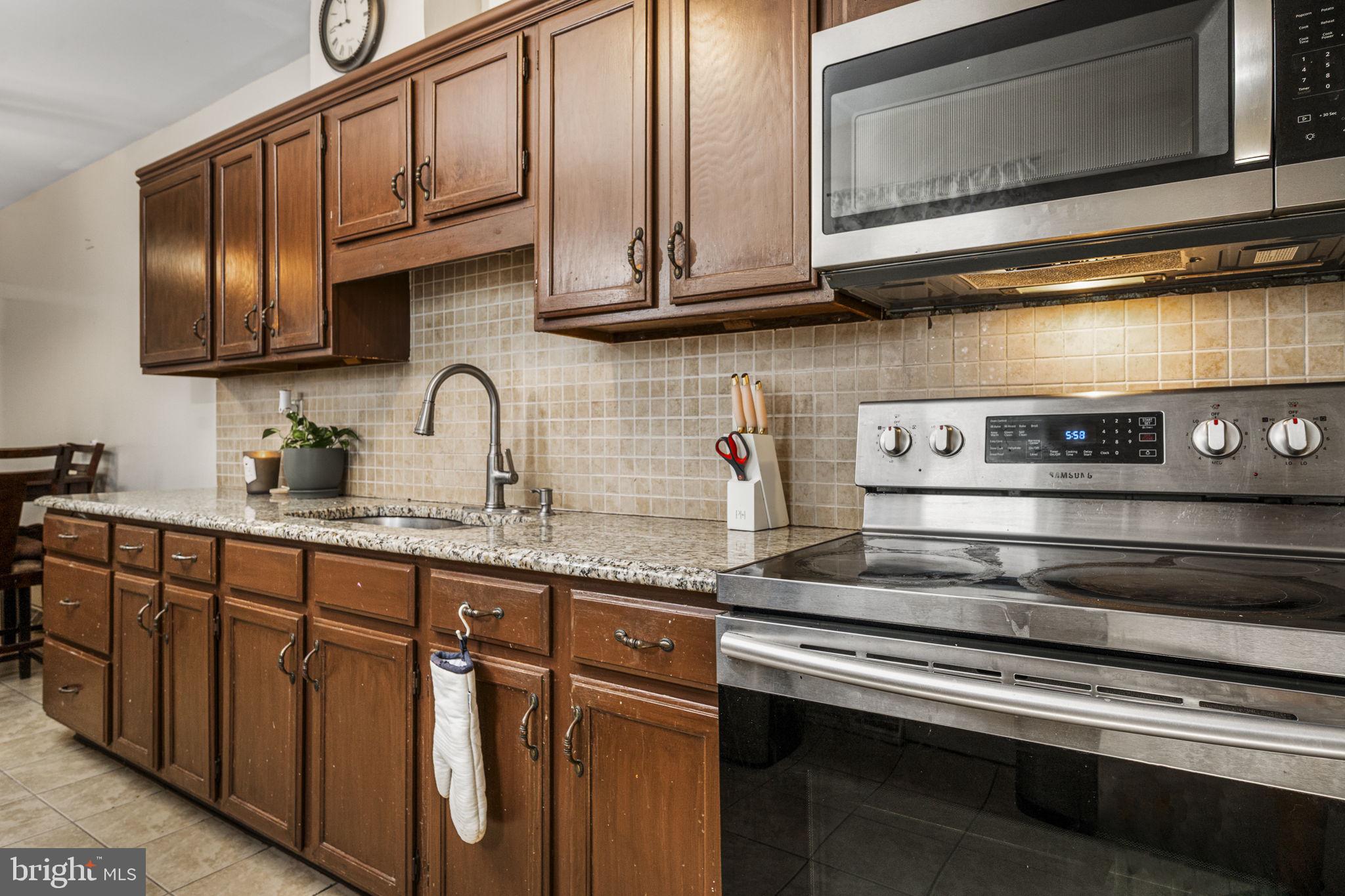 115 Park Avenue Reading, PA 19605 - Photo 8 of 28 a kitchen with stainless steel appliances granite countertop a sink stove and microwave