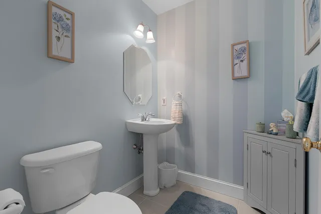 a bathroom with a toilet a sink and a mirror