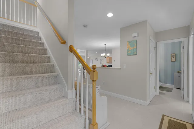 a view of staircase with white walls and door