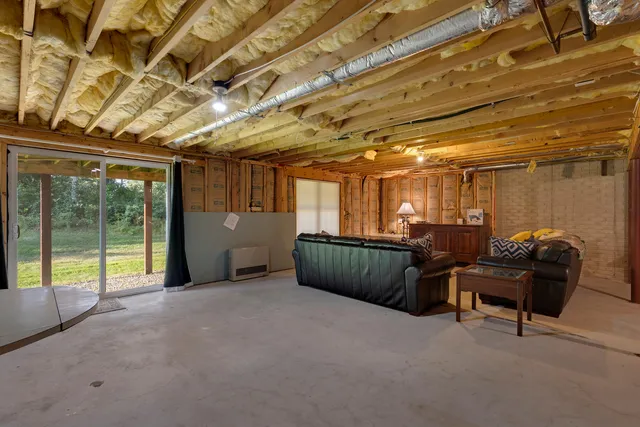 a view of a sink and backyard with large trees