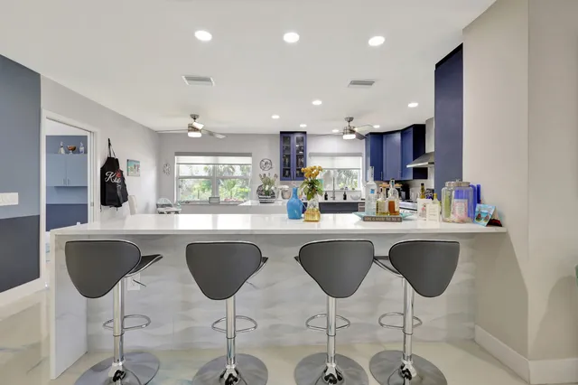 a kitchen with stainless steel appliances granite countertop a table and chairs in it
