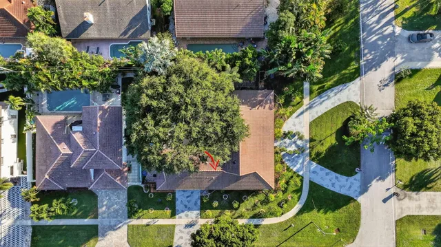 an aerial view of residential houses with outdoor space and trees