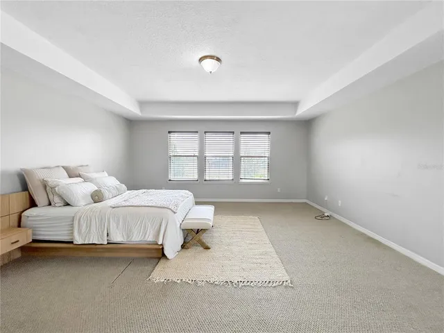 a spacious bedroom with a bed and a window