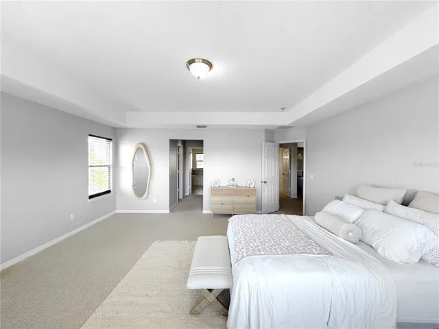 a spacious bedroom with a large bed and windows