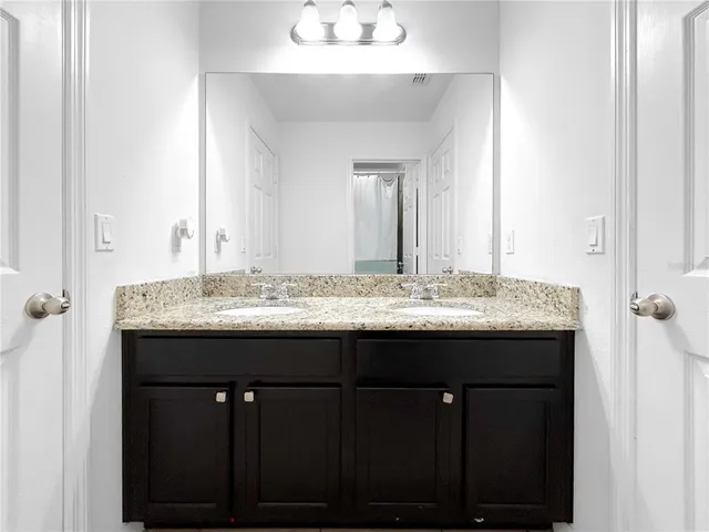 a bathroom with a granite countertop sink and a mirror
