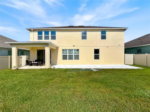 a view of a house with backyard and sitting area