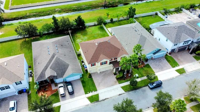 an aerial view of a house with a garden and lake view