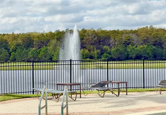 a view of a swimming pool with a small garden and wooden fence