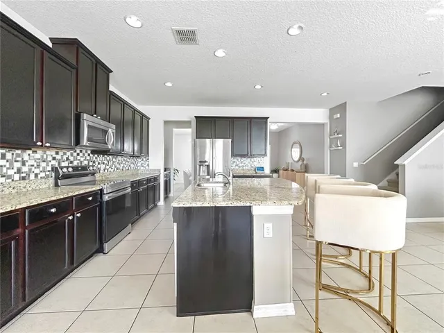 a kitchen with stainless steel appliances kitchen island granite countertop a stove and cabinets