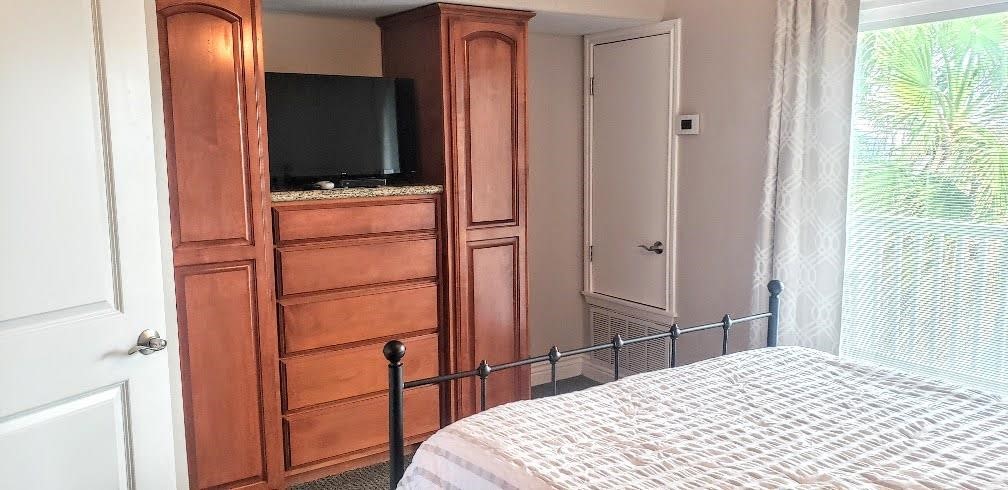 2290 North Fulton Beach Road, Unit B317 Rockport, TX 78382 - Photo 17 of 40 a bedroom with a bed and a flat tv screen on dresser