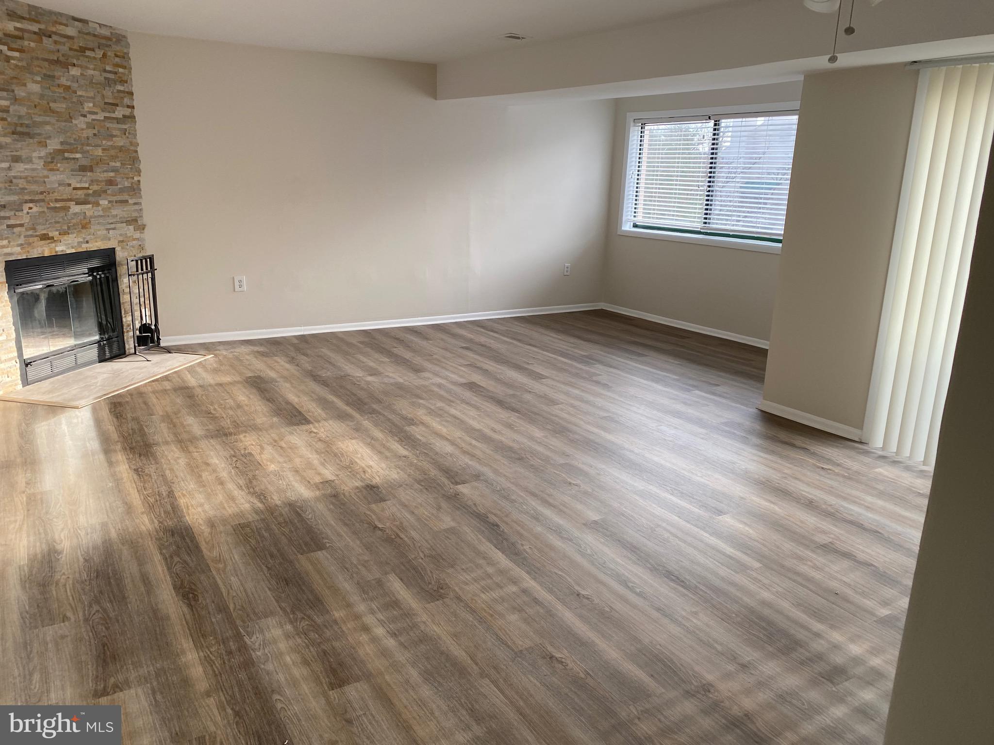 6 Winners Circle, Unit 3C Owings Mills, MD 21117 - Photo 11 of 26 an empty room with wooden floor fireplace and windows