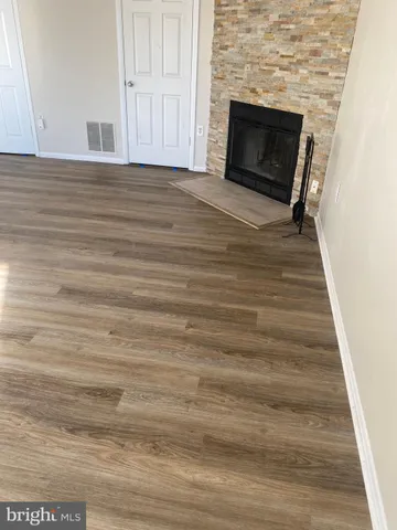a view of empty room with wooden floor and fireplace