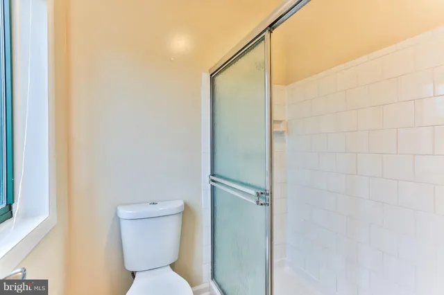 a bathroom with a toilet and a shower