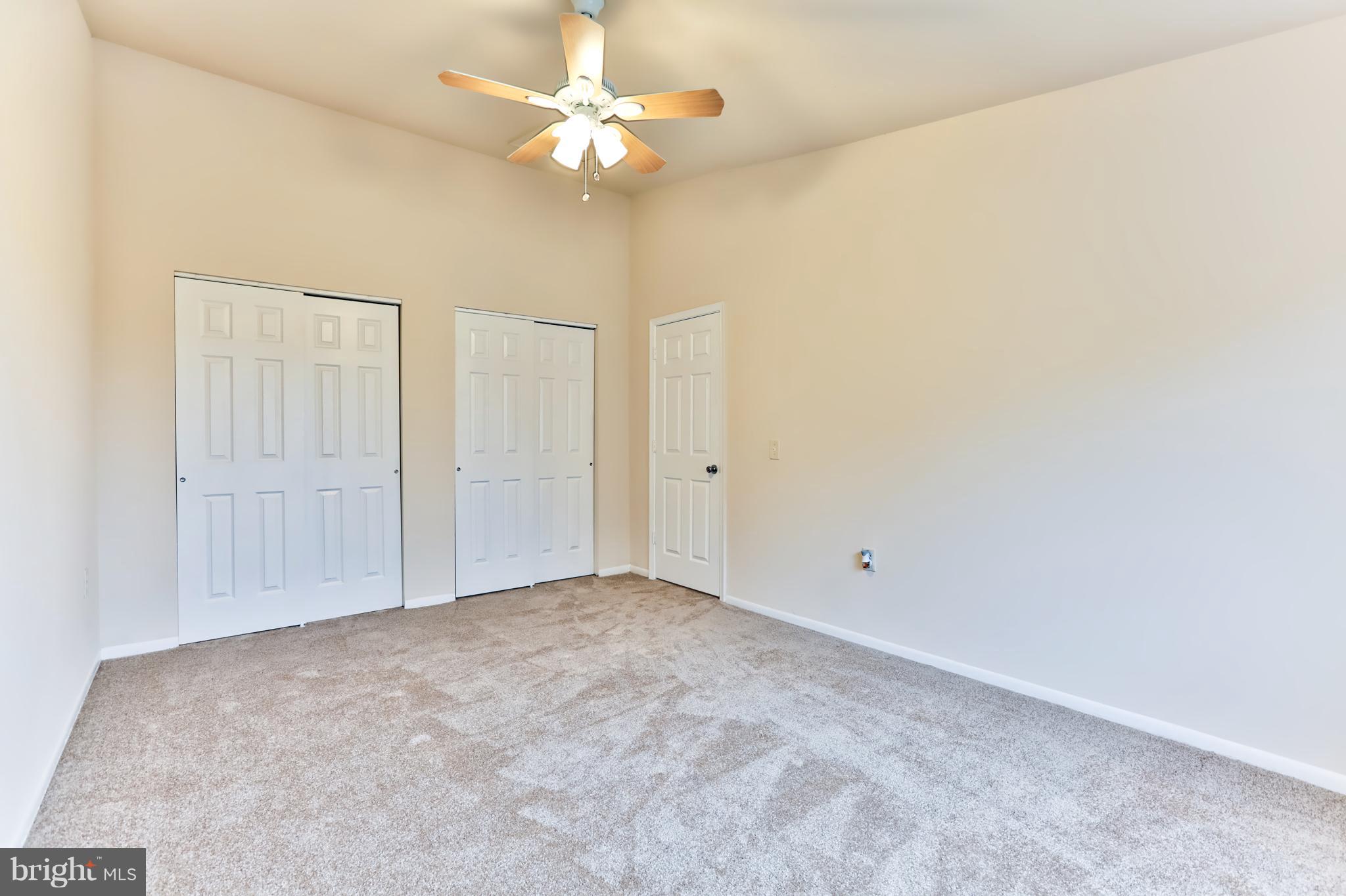 6 Winners Circle, Unit 3C Owings Mills, MD 21117 - Photo 23 of 26 an empty room with a chandelier fan and windows
