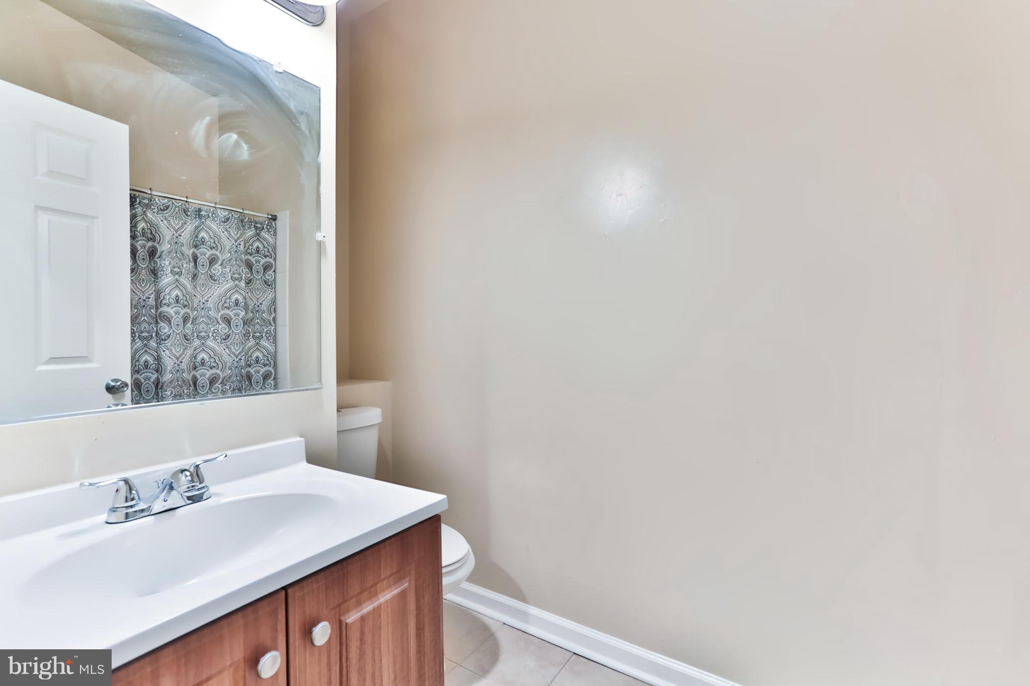 6 Winners Circle, Unit 3C Owings Mills, MD 21117 - Photo 24 of 26 a bathroom with a sink vanity and a mirror