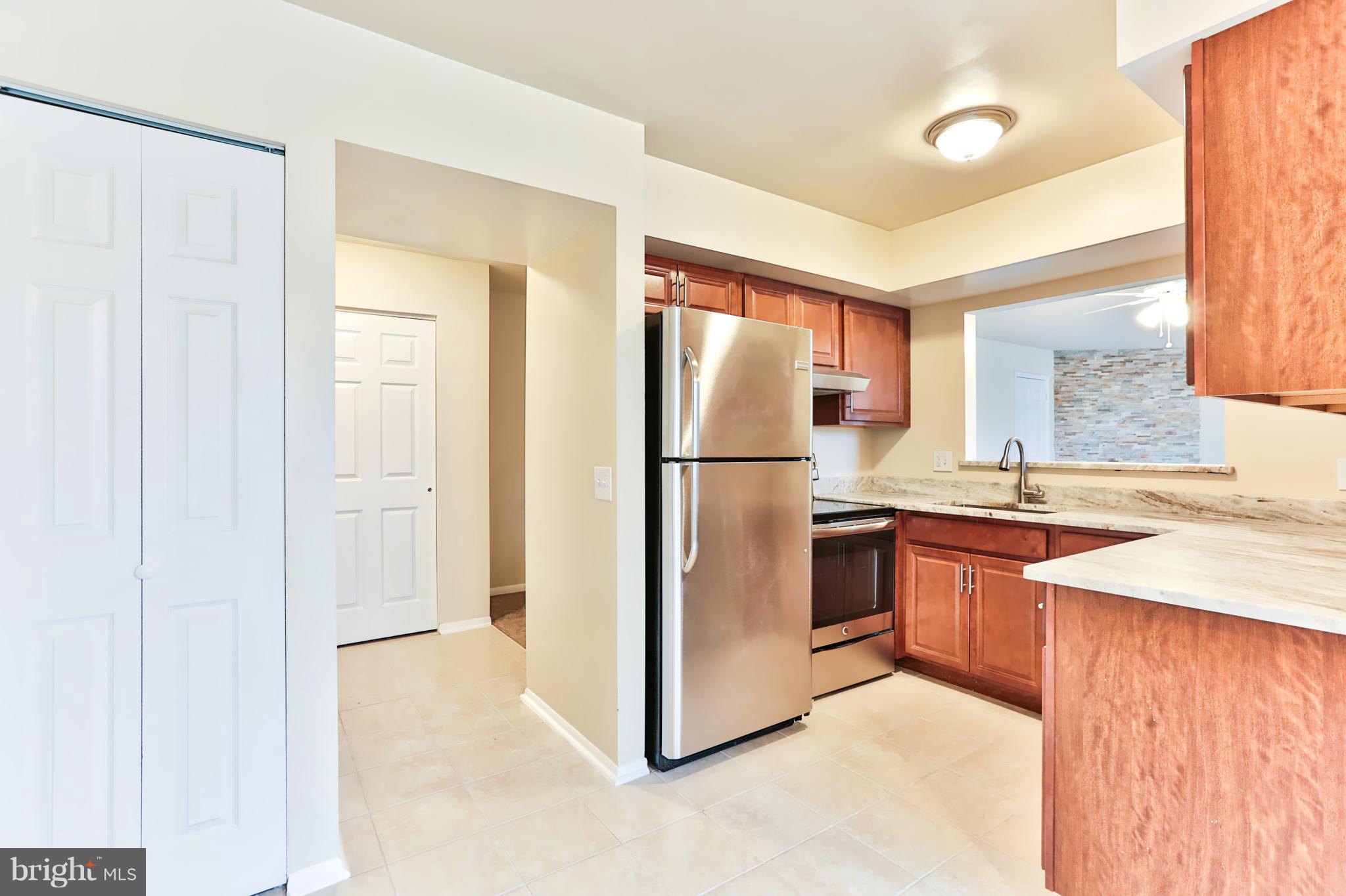 6 Winners Circle, Unit 3C Owings Mills, MD 21117 - Photo 5 of 26 a kitchen with stainless steel appliances granite countertop a refrigerator and a sink
