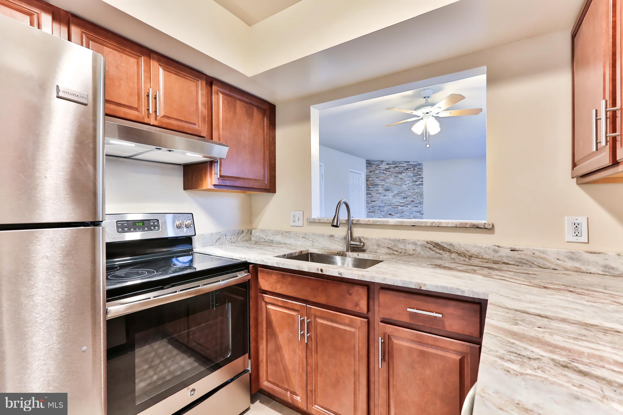6 Winners Circle, Unit 3C Owings Mills, MD 21117 - Photo 8 of 26 a kitchen with granite countertop a sink stove and cabinets