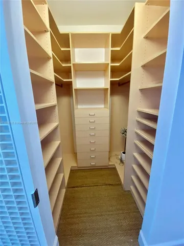 a view of walk in closet with empty tub