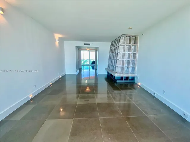 a view of an empty room with a window and a fireplace