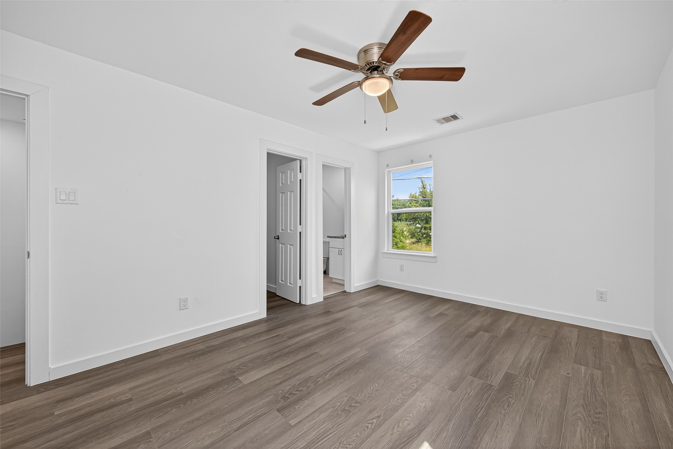 9405 Madera Road Houston, TX 77078 - Photo 18 of 32 an empty room with wooden floor ceiling fan and windows