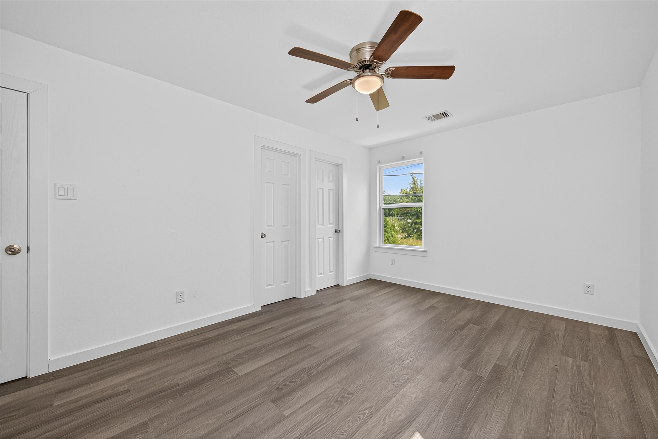 9405 Madera Road Houston, TX 77078 - Photo 19 of 32 an empty room with wooden floor ceiling fan and windows