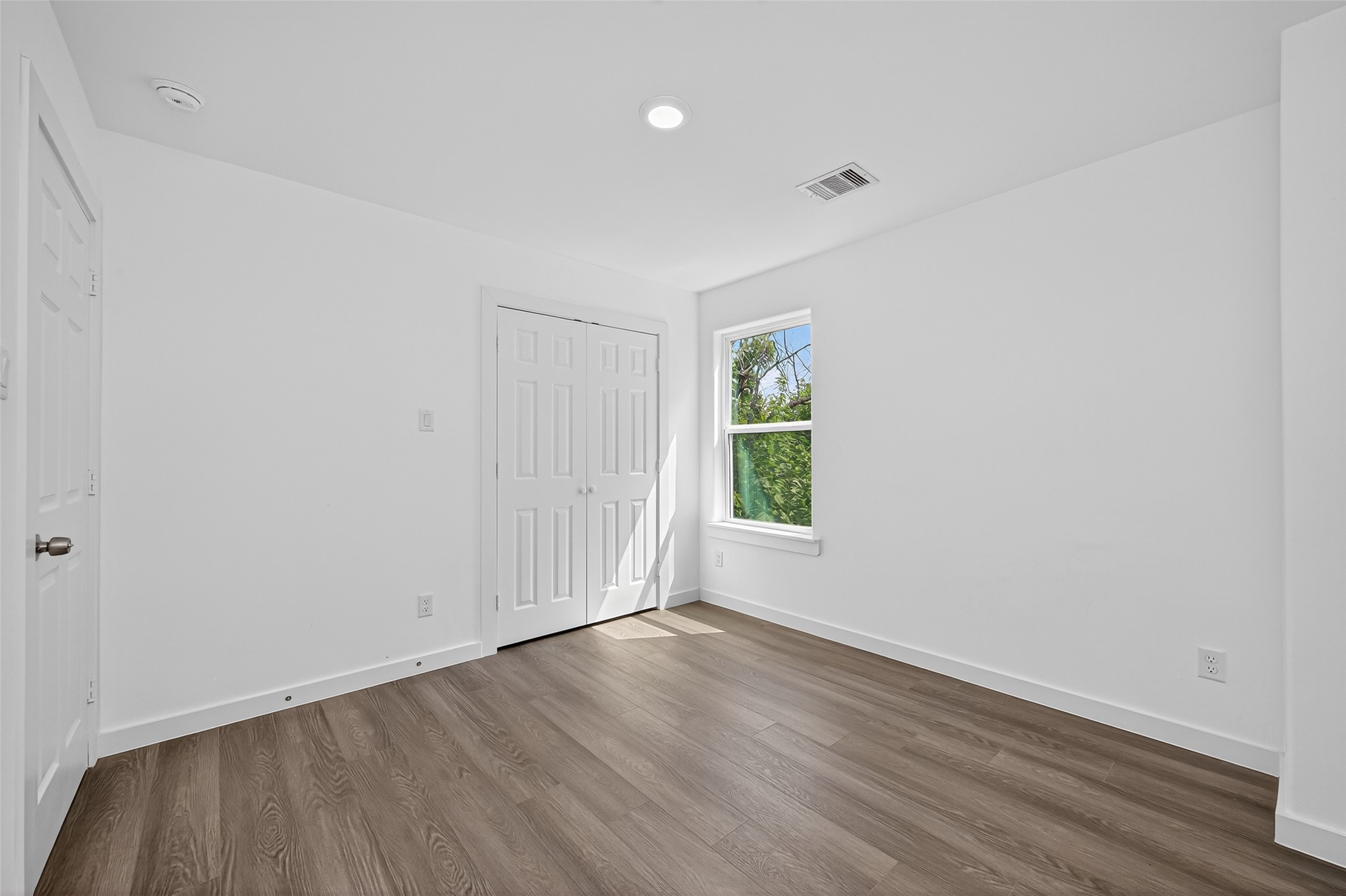 9405 Madera Road Houston, TX 77078 - Photo 26 of 32 an empty room with wooden floor and windows