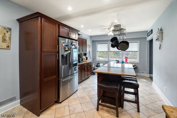 a kitchen with stainless steel appliances granite countertop a refrigerator and a sink
