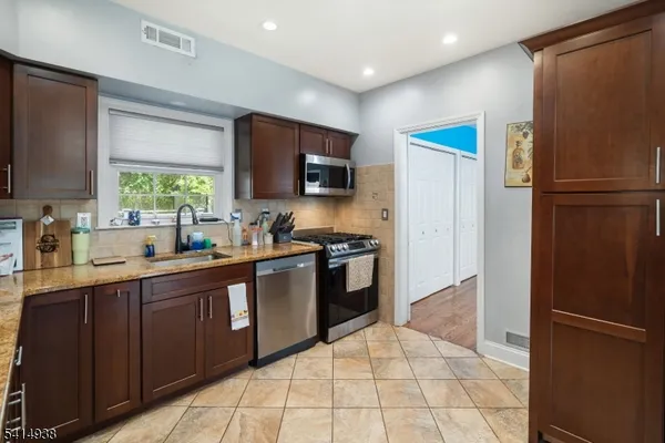 a kitchen with stainless steel appliances a refrigerator stove microwave and sink