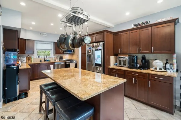 a kitchen with stainless steel appliances chandelier dining table and chairs