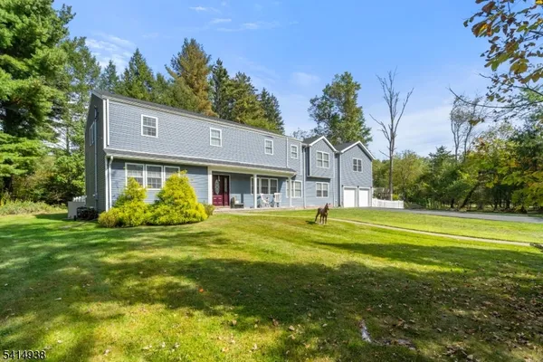 a front view of house with garden and trees