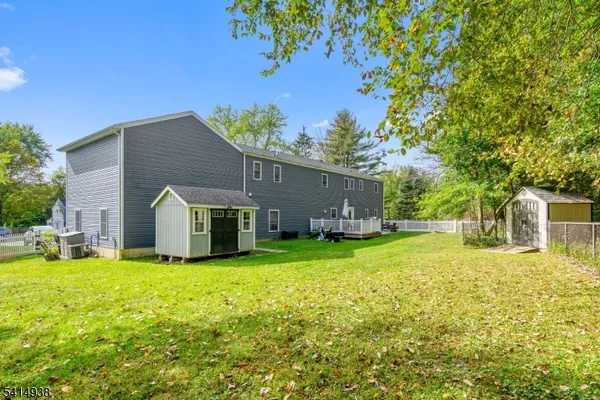 a front view of house with yard and trees in the background