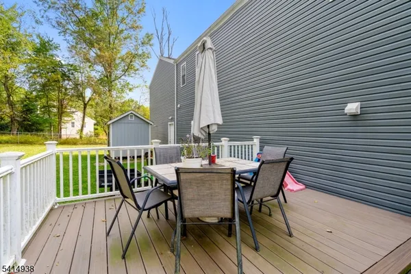 a view of a roof deck with table and chairs and wooden floor