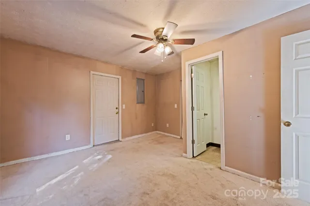 an empty room with closet and a ceiling fan