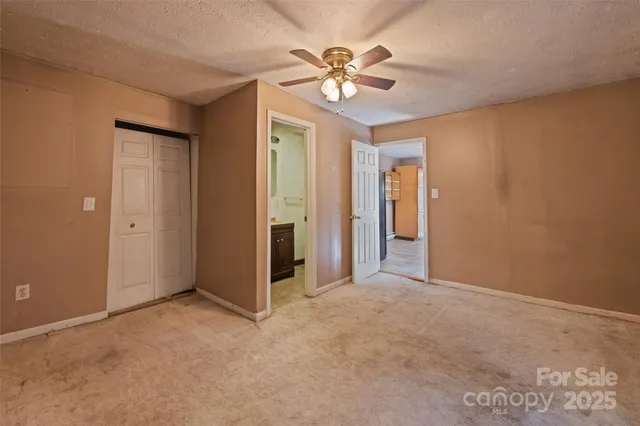 an empty room with a ceiling fan and a window